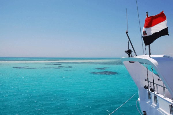 Boat on clear turquoise water with flag