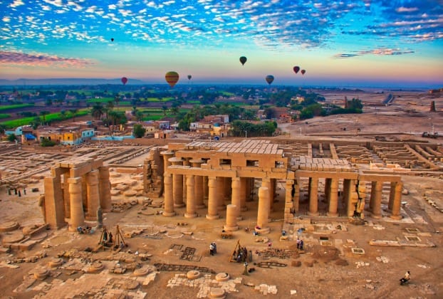 Hot air balloons over ancient Egyptian temple ruins admire during a multi-day Egypt excursions and Egypt tour package with Discovery Tours Egypt.