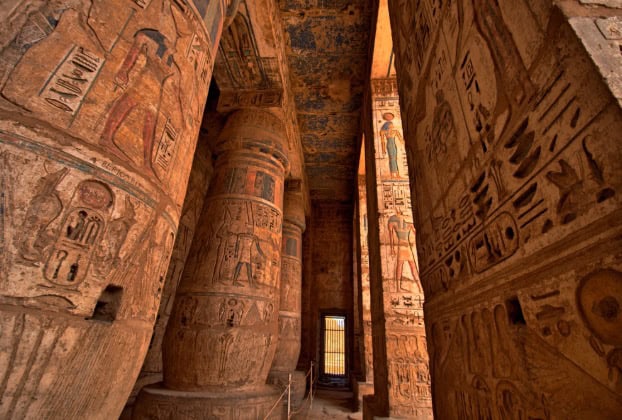 Ancient Egyptian pillars with intricate carvings admired during an Egypt tour packages.