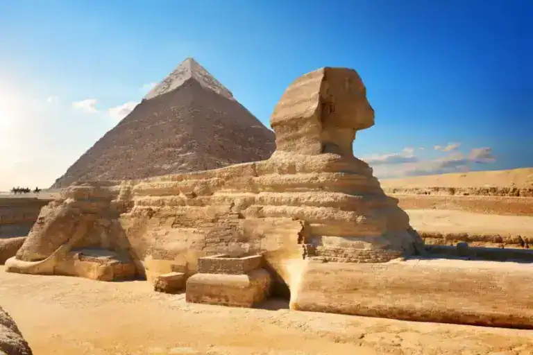 Ancient Sphinx with Pyramid behind it being admired by tourist on an Egypt DMC group tour.