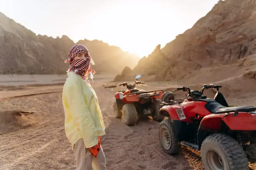 Young Girl With A Covered Face Preparing For A Desert Safari On Atvs Young girl with a covered face preparing for a desert safari on ATVs Hurghada Desert Safari